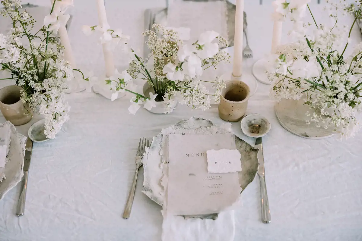 moderni minimalismi hääkattaus lautaset ja hääkukat pöydällä